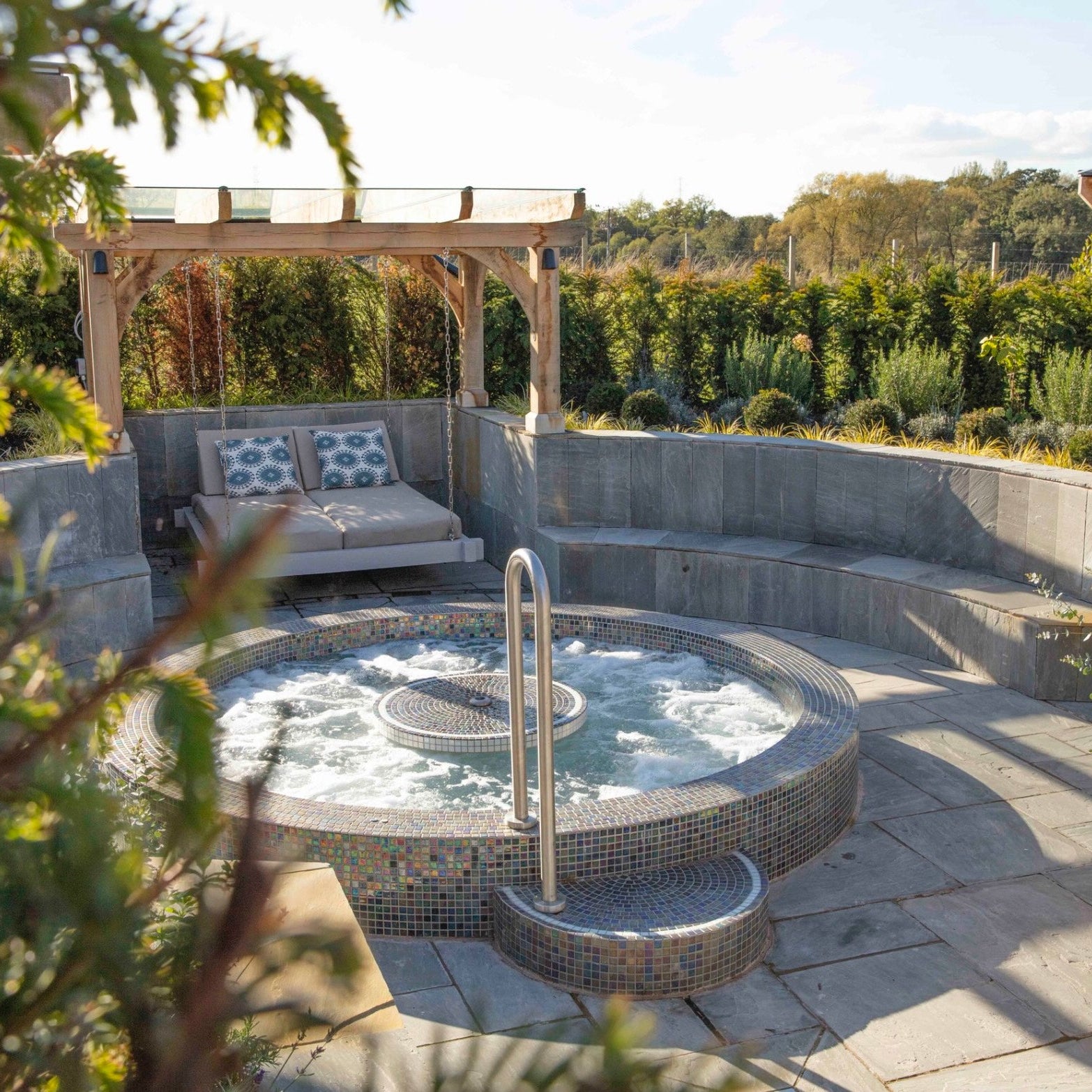 Mosaic round vitality spa pool for 4 persons by Spa Living, showing colorful mosaic interior and comfortable seating.